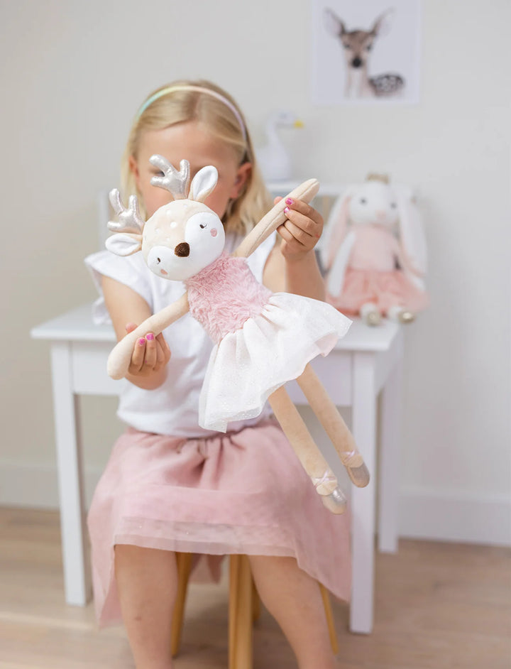 Child playing with a soft plush reindeer toy wearing a pink tutu dress and ballet shoes, Ballerina Deer Ruth by Teddykompaniet, sold by Baby Belle.