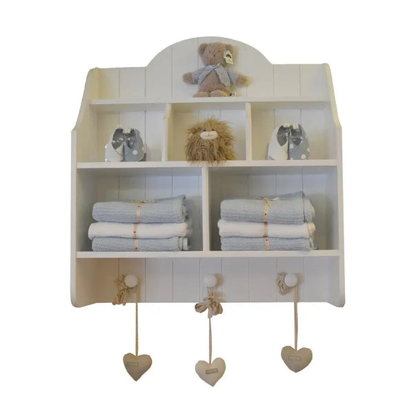White Lyra wall shelf with open cubbies, pigeon holes, tongue-and-groove detail and three rounded hooks, styled for nursery or kids’ room
