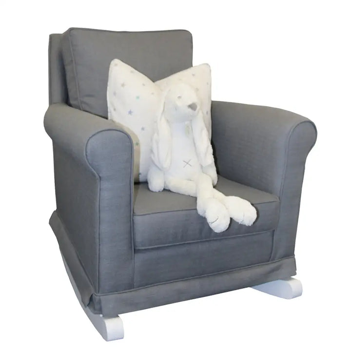 Tres Chic Rocking Chair in charcoal grey fabric with white wooden rocking legs, styled with a star-print cushion and plush bunny toy.