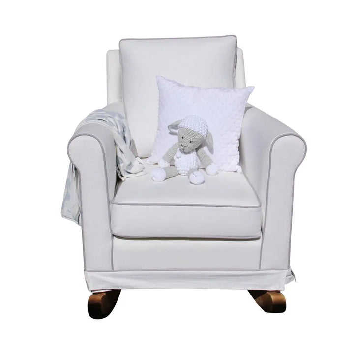 Tres Chic Rocking Chair in white with solid wooden rocking legs, featuring a plush cushioned seat styled with a toy lamb and throw blanket.