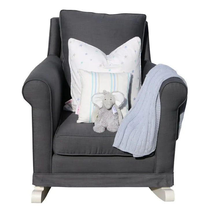 Tres Chic Rocking Chair in charcoal with hand-painted white rocking legs, styled with star and stripe scatter cushions, a plush grey elephant, and a soft blue throw for a modern nursery setting.