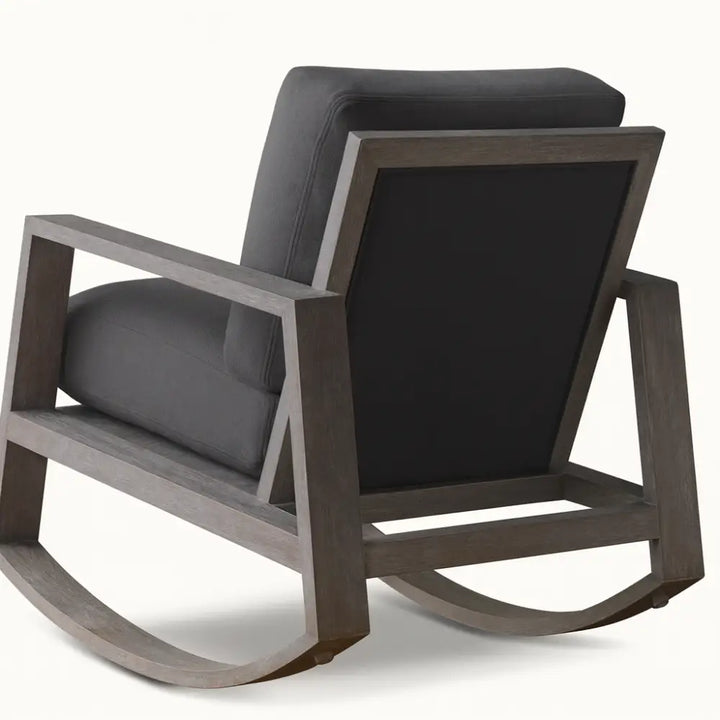 Modern Harvey rocking chair with a weathered wood frame and charcoal upholstered cushions, featuring clean geometric lines and a contemporary silhouette.