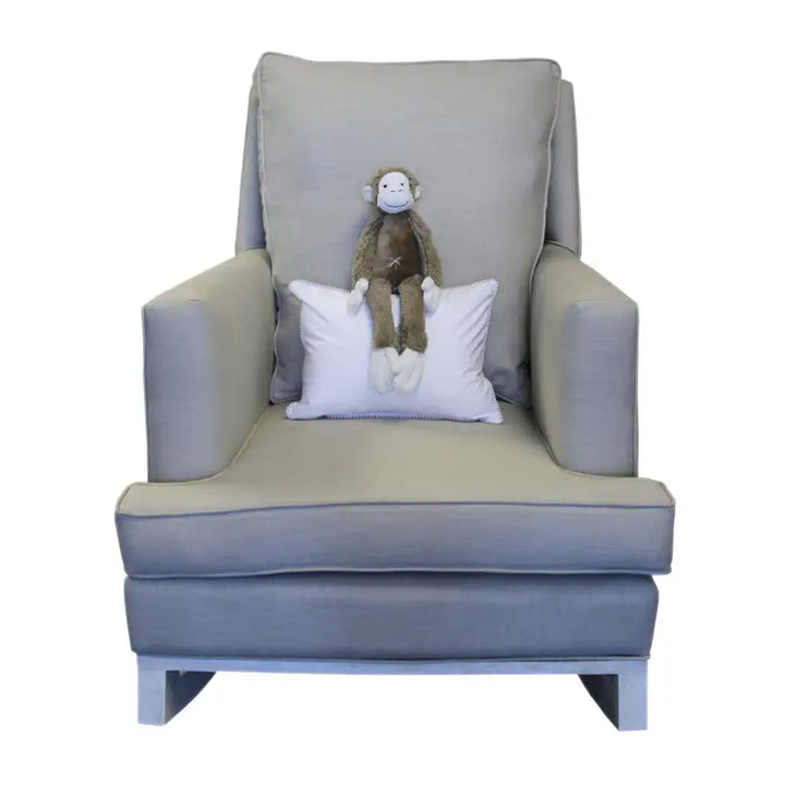 Grey Jayden rocking chair with a cushioned back and seat, featuring a white accent pillow and a plush toy monkey placed at the center.