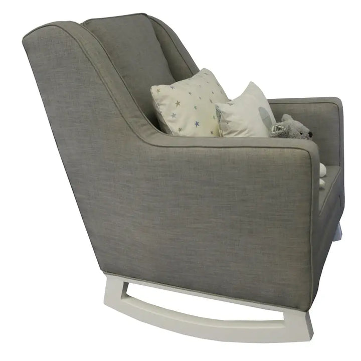 The Mathew Rocking Chair from Baby Belle, upholstered in grey fabric with a modern wingback design, padded seat, and wooden rocking base, crafted for comfort and style in the nursery or living space.